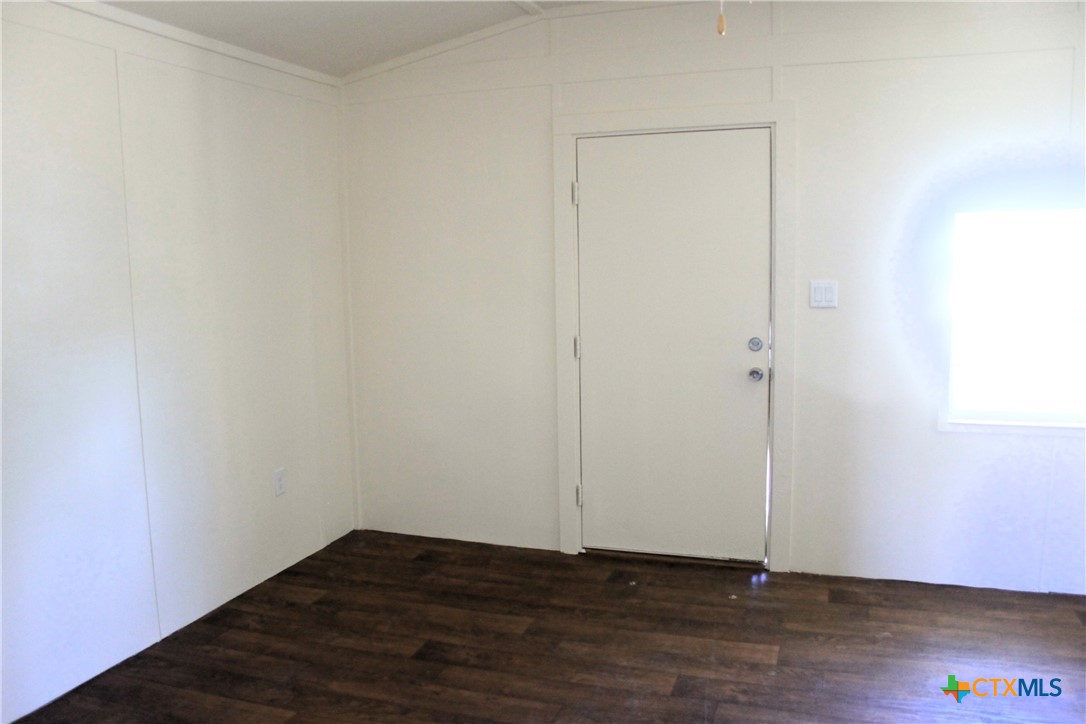 301 Cedar Street, Unit A Lometa, TX 76853 - Photo 13 of 13 a view of an empty room with wooden floor