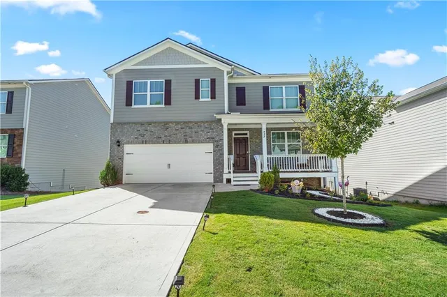 a front view of a house with a yard and garage