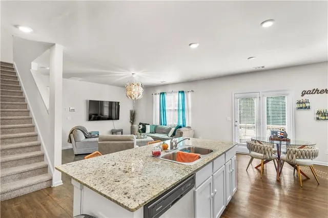 a kitchen with stainless steel appliances granite countertop a sink a stove and a refrigerator