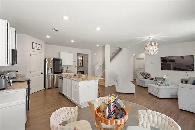 a living room with furniture kitchen view and a refrigerator
