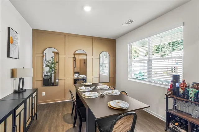 a view of a a dining room with furniture window and wooden floor