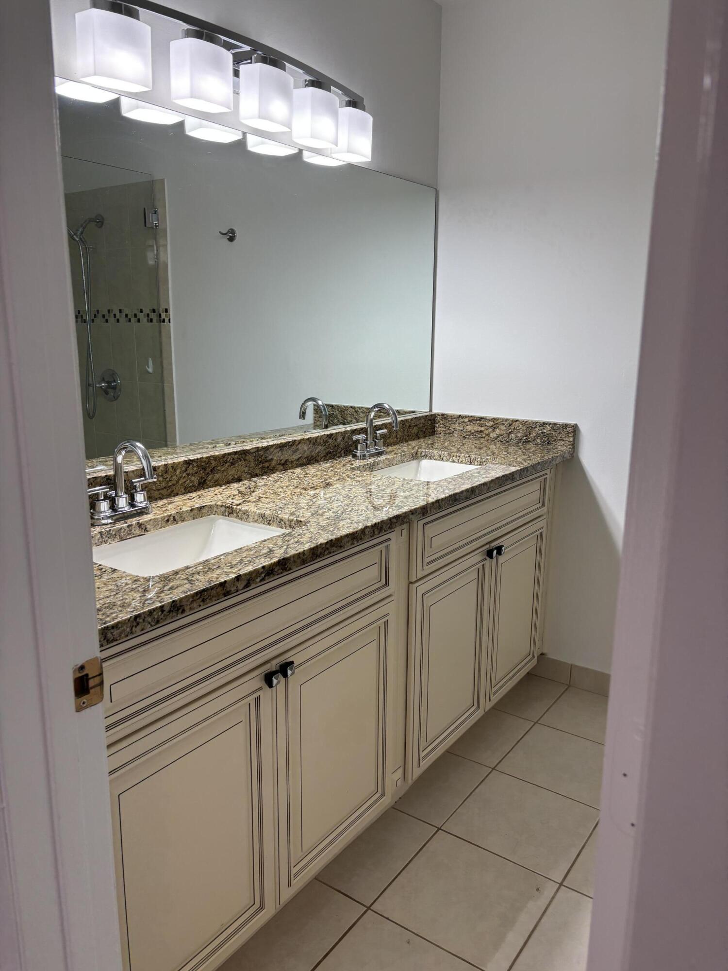 11608 Orange Blossom Lane Boca Raton, FL 33428 - Photo 14 of 18 a bathroom with a granite countertop sink a mirror and vanity