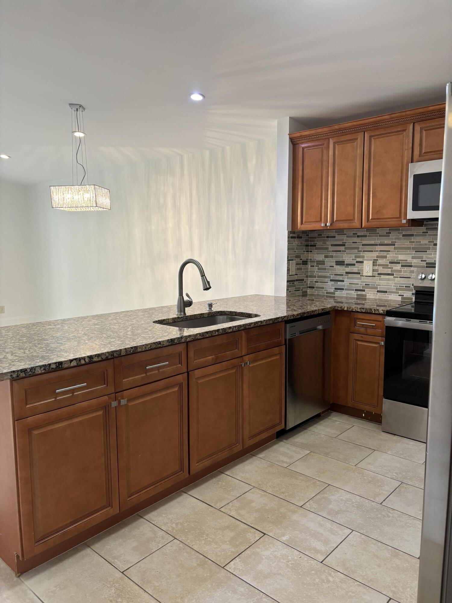 11608 Orange Blossom Lane Boca Raton, FL 33428 - Photo 3 of 18 a kitchen with stainless steel appliances granite countertop a sink and cabinets