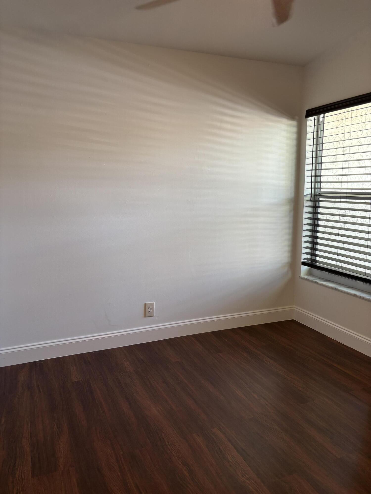 11608 Orange Blossom Lane Boca Raton, FL 33428 - Photo 7 of 18 a view of an empty room with wooden floor and a window