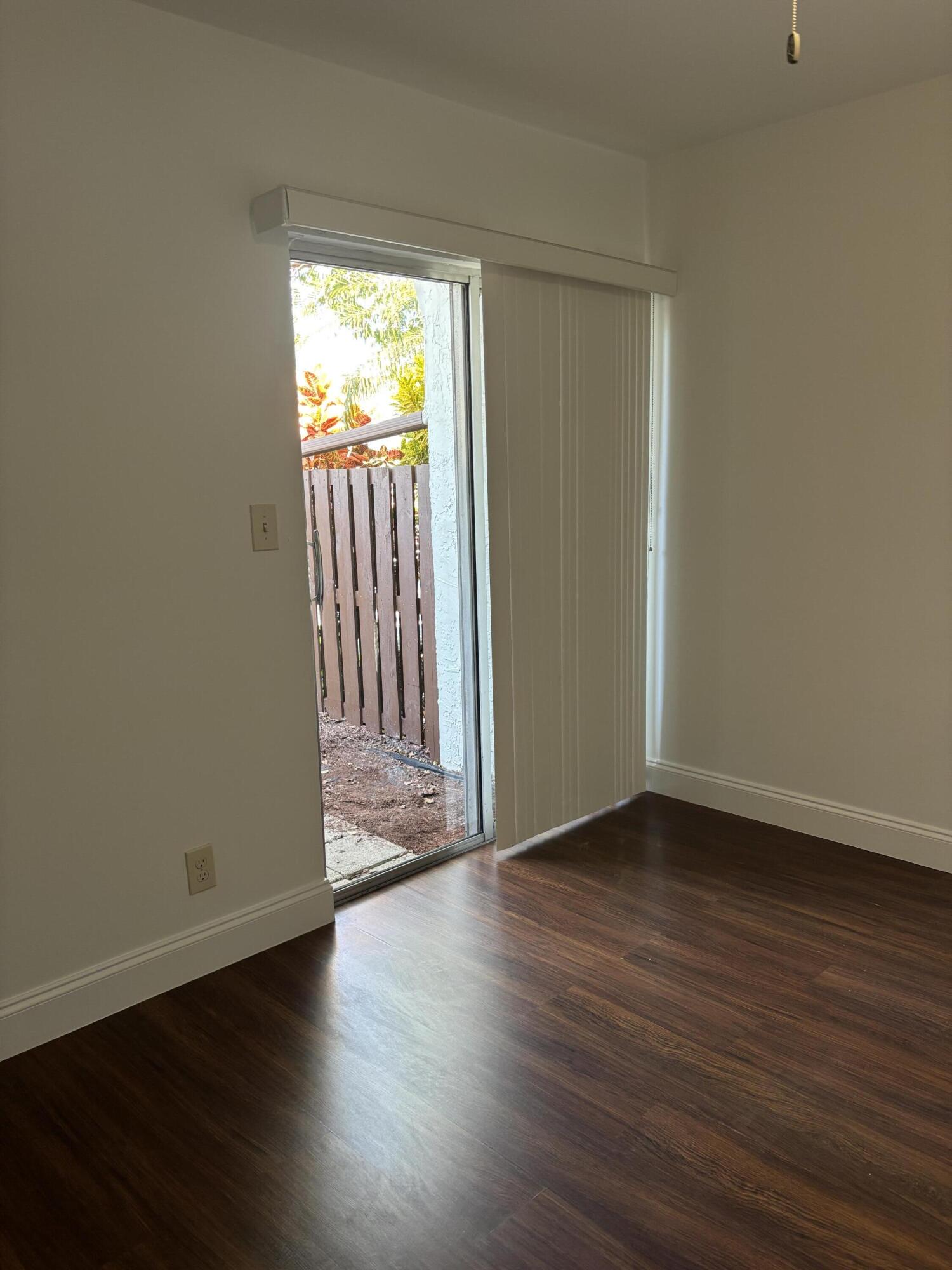 11608 Orange Blossom Lane Boca Raton, FL 33428 - Photo 9 of 18 a view of an empty room with wooden floor and a window