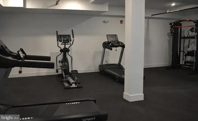 a view of gym equipment with wooden floor