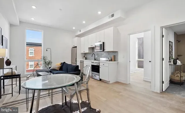 a kitchen with refrigerator cabinets dining table and chairs