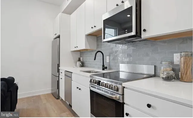 a kitchen with stainless steel appliances granite countertop a sink and a microwave