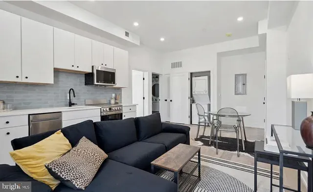 a living room with furniture a kitchen island with the kitchen view