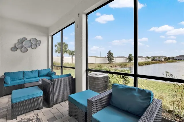 a living room with furniture and a floor to ceiling window