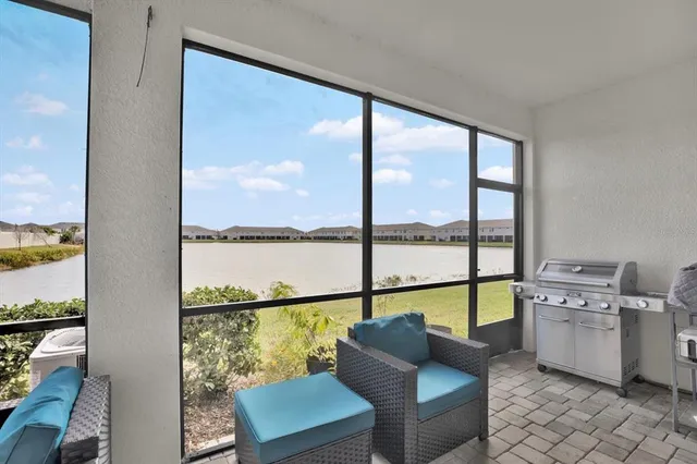 a living room with furniture and floor to ceiling windows