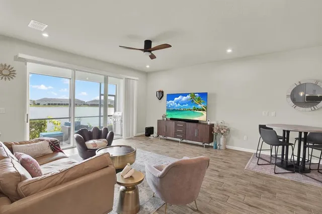 a living room with furniture a floor to ceiling window and a flat screen tv