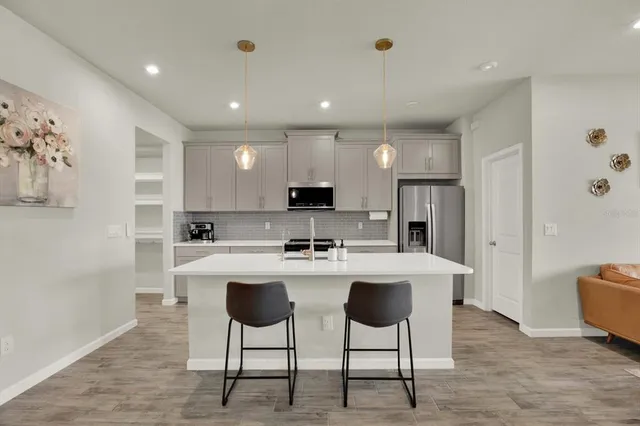 a kitchen with kitchen island appliances cabinets and chair