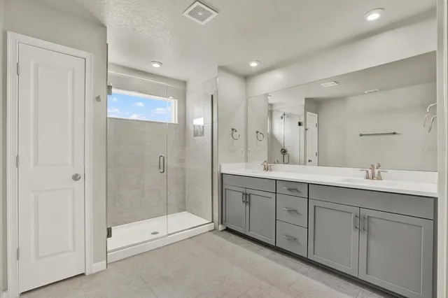 a spacious bathroom with double sink and shower