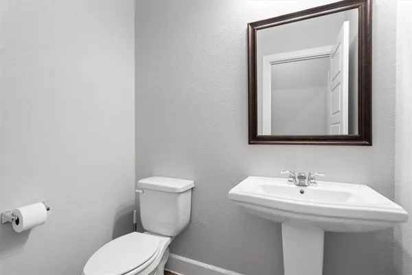 a bathroom with a toilet a sink and mirror