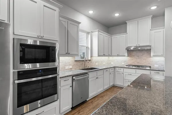 a kitchen with stainless steel appliances granite countertop a stove and a microwave