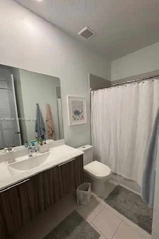 a bathroom with a double vanity sink toilet and a mirror