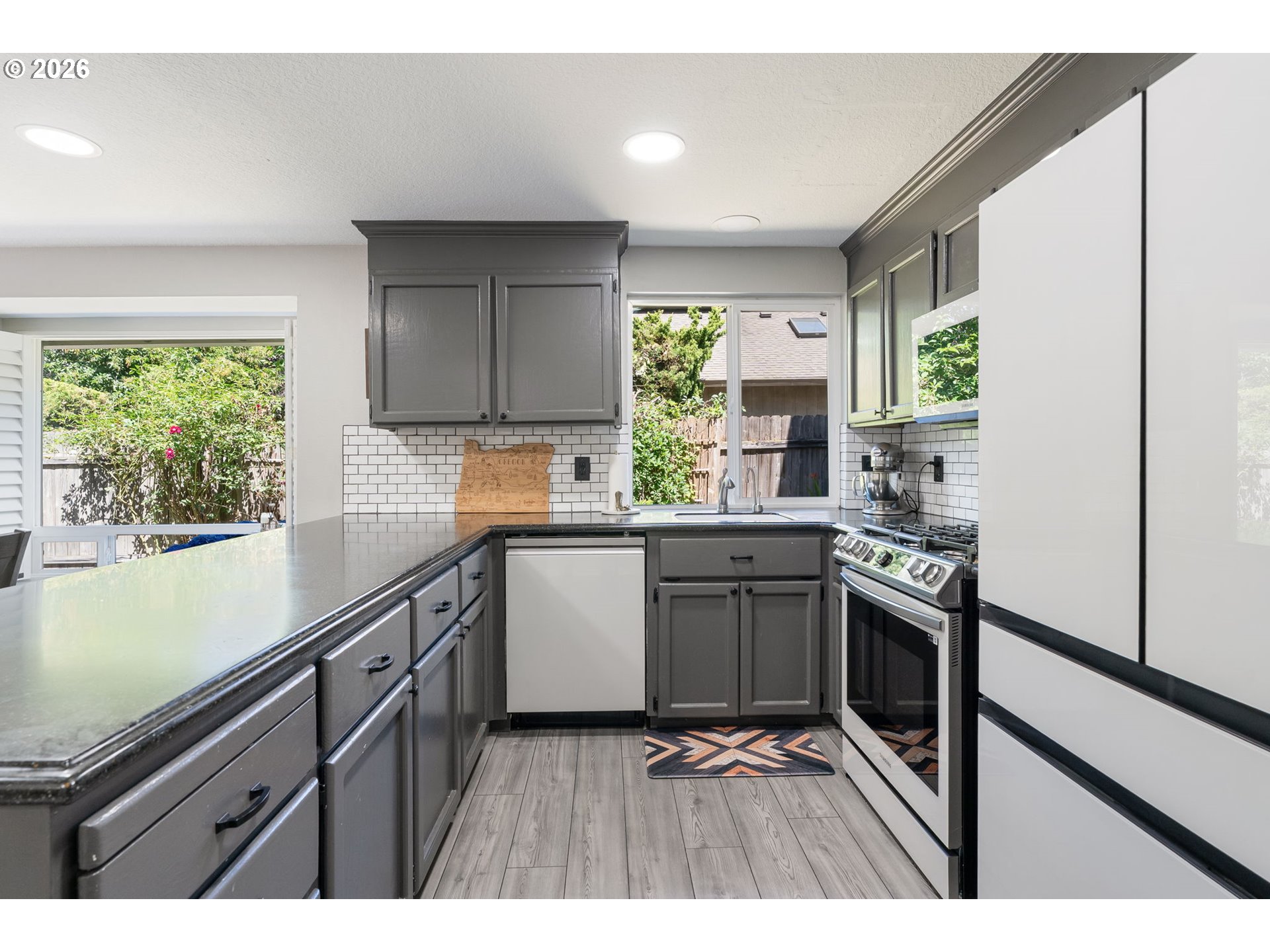 14877 Southwest Oregon Trail Lane Beaverton, OR 97006 - Photo 8 of 41 a kitchen with granite countertop a stove a sink and a refrigerator