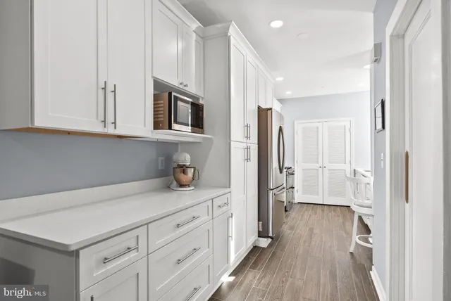 a kitchen with stainless steel appliances white cabinets and a refrigerator