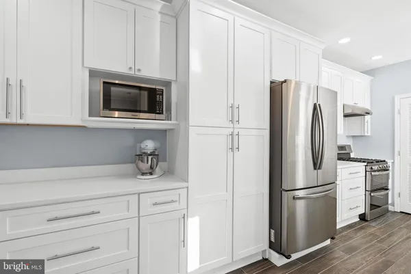 a kitchen with stainless steel appliances white cabinets and a stove