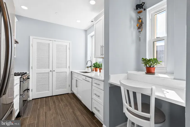 a kitchen with white cabinets and white appliances