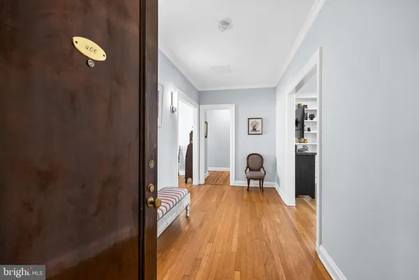 a view of a hallway with a wooden floor and a bathroom