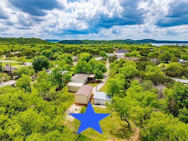 1926 Roadrunner Road Graford, TX 76449 - Photo 2 of 37 LOCATED ON THE PK PENINSULA CLOSE TO ALL THE BEST AMENITIES & DINING. GREAT LOT WITH MATURE SHADE AND TREES AND BIG GRASSY LAWNS