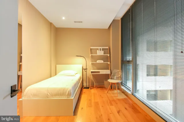 a bedroom with a bed and wooden floor