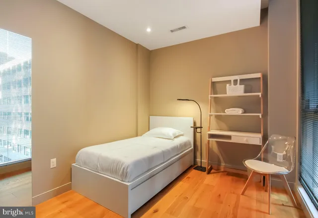 a bedroom with a bed and a large window