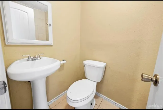 a bathroom with a toilet a sink and mirror