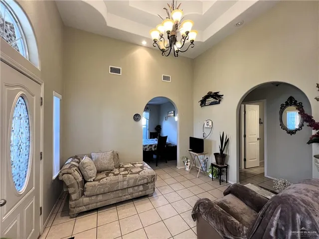 a living room with furniture a fireplace and chandelier