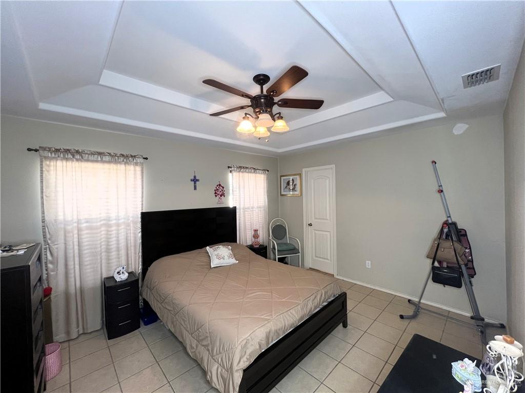 613 South Moorefield Road Mission, TX 78572 - Photo 9 of 19 a bedroom with a bed and a chandelier