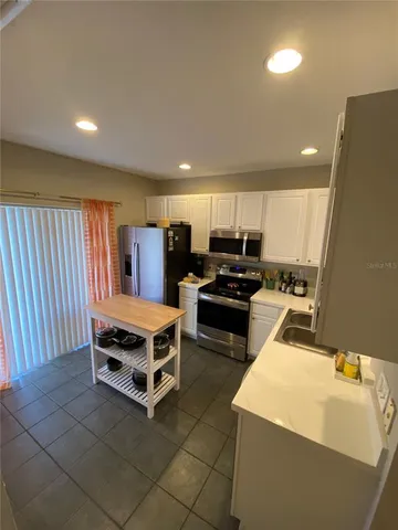 a kitchen with a refrigerator a stove a sink and a microwave