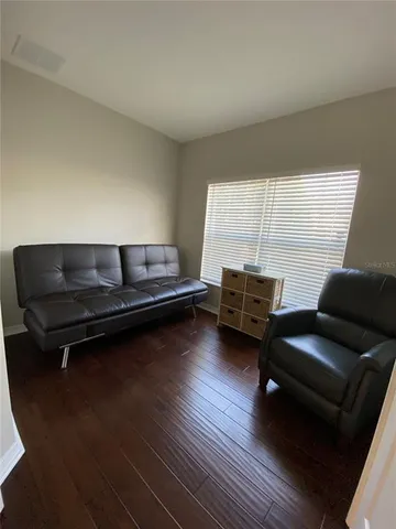a living room with furniture and a wooden floor