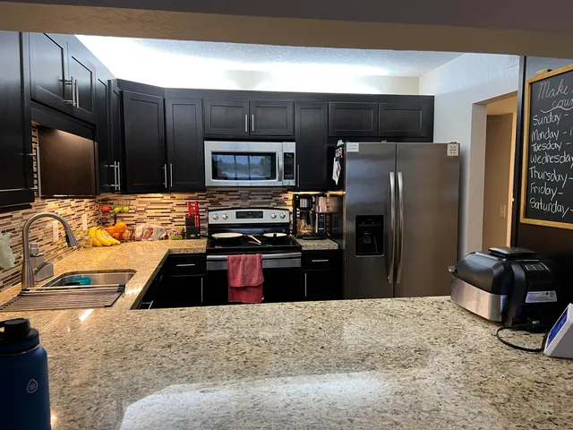 a large kitchen with a stove and refrigerator