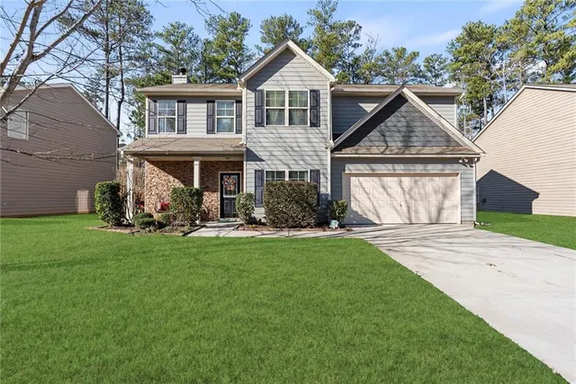 a front view of a house with a yard and garage