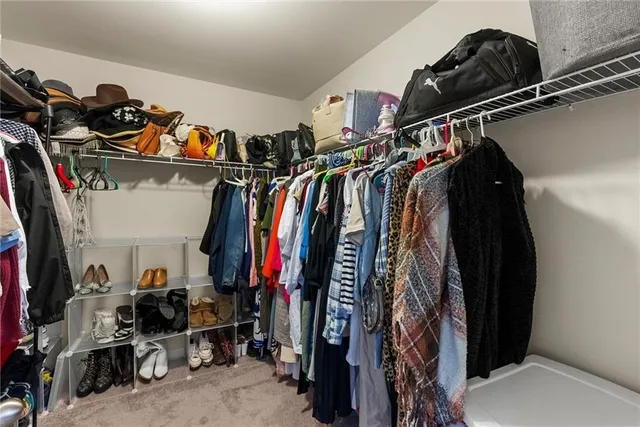 a view of walk in closet with clothes and shoes