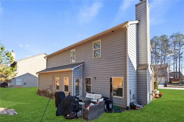 a backyard of a house with barbeque oven and a fire pit