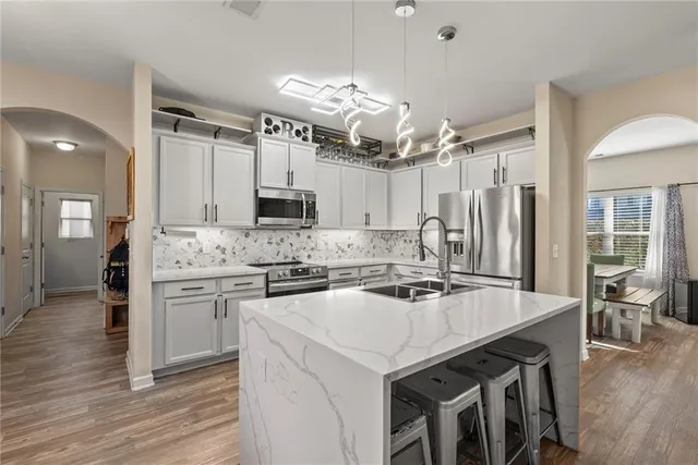 a kitchen with granite countertop a sink appliances cabinets and wooden floor