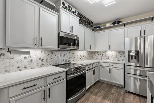 a kitchen with appliances a sink and cabinets