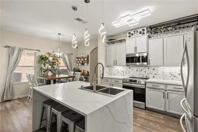 a kitchen with stainless steel appliances granite countertop a sink stove and refrigerator
