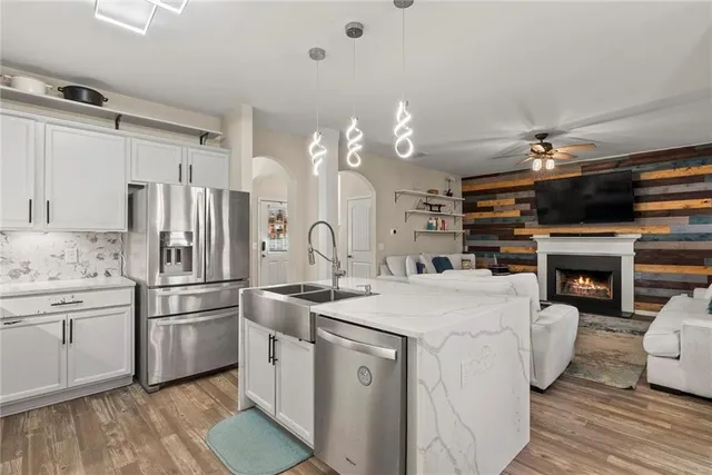 a kitchen with kitchen island a stove a sink and a fireplace