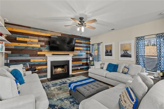 a living room with furniture a flat screen tv and a fireplace