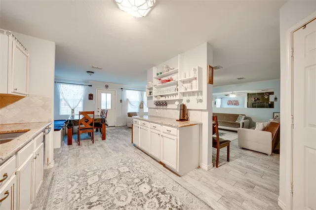 a kitchen filled with white cabinets and sink