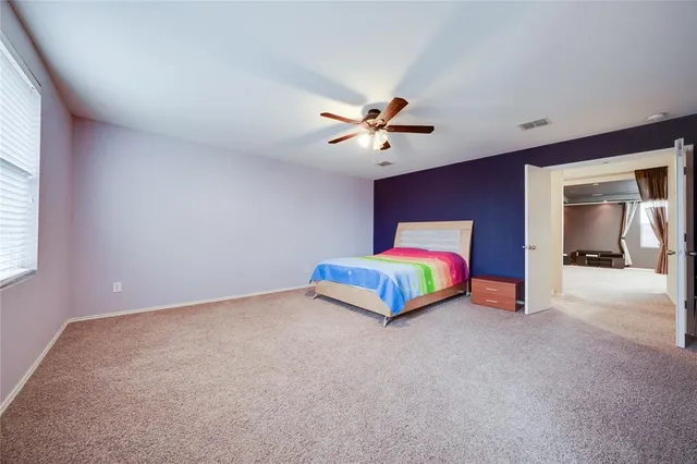 a bedroom with a bed and a ceiling fan