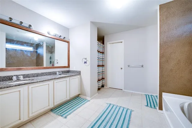 a spacious bathroom with a granite countertop sink and a mirror