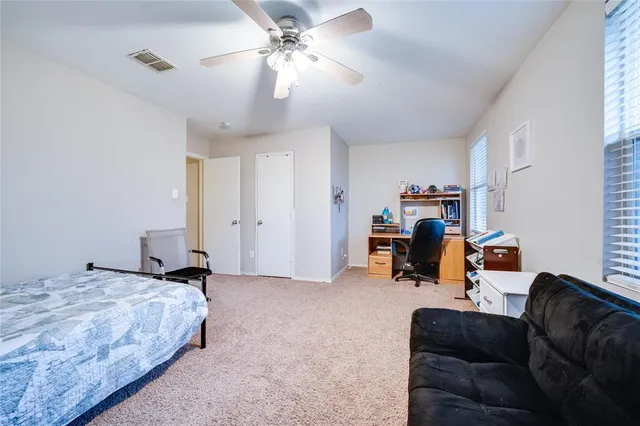 a bedroom with furniture and a ceiling fan
