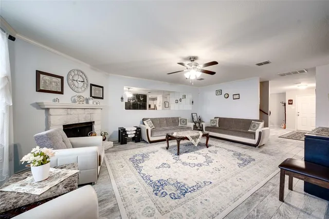a living room with furniture a fireplace and a chandelier