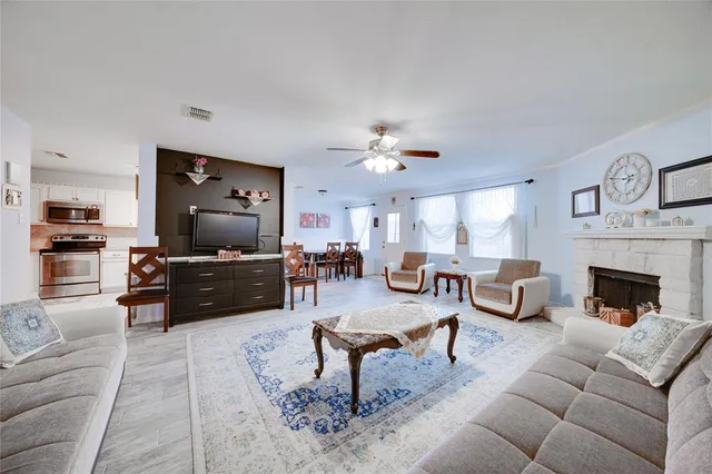 a living room with furniture a fireplace and a flat screen tv