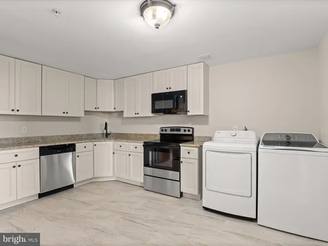 a kitchen with appliances a sink and cabinets